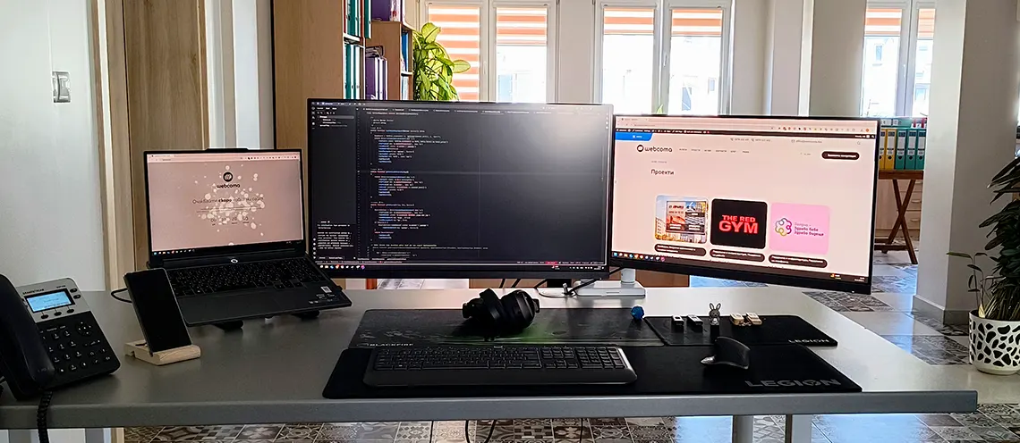 Работно място с монитори, лаптоп, телефон - Професионална уеб разработка за бизнес нужди и дигитални проекти - УебКома ООД