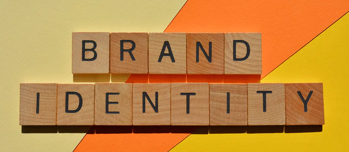 Дървени купчета с букви изписали "Бранд идентичност" - Професионална уеб разработка за бизнес нужди и дигитални проекти - УебКома ООД