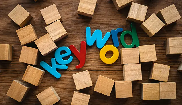Дървани кубчета и дървени букви изписали "ключова дума" - Професионална уеб разработка за бизнес нужди и дигитални проекти - УебКома ООД